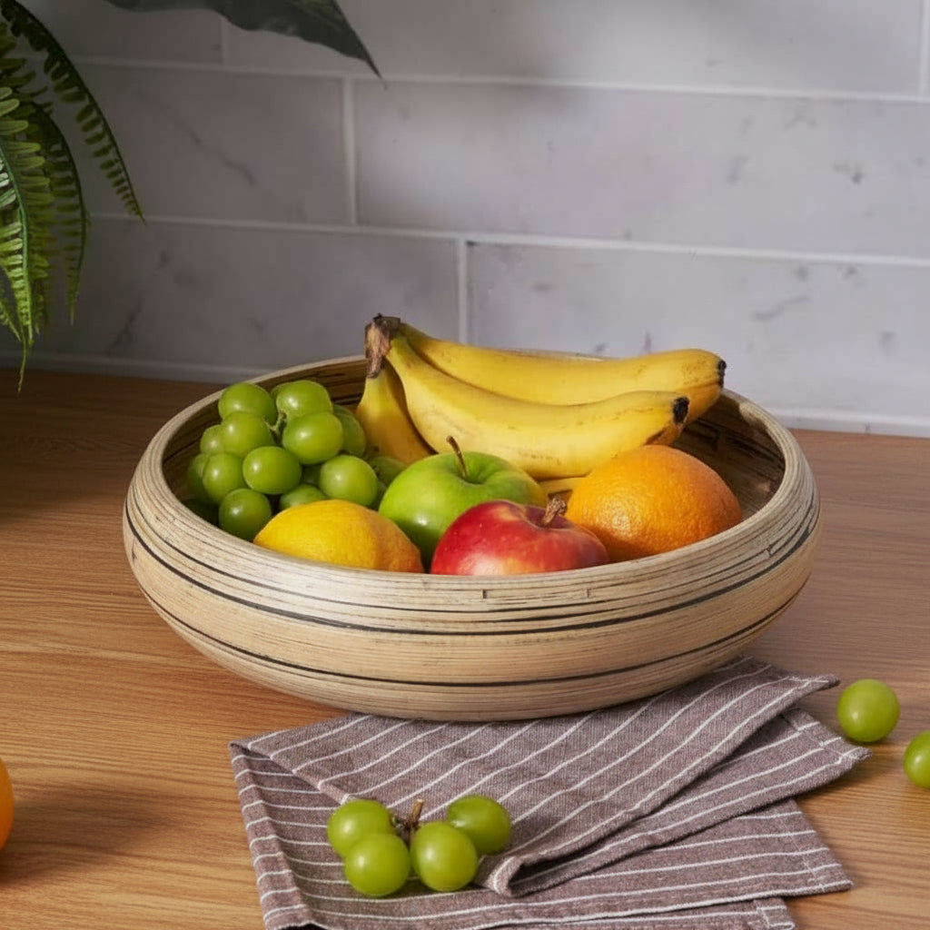 Bol en bambou rempli de fruits posé sur un plan de travail, ambiance cuisine chaleureuse.