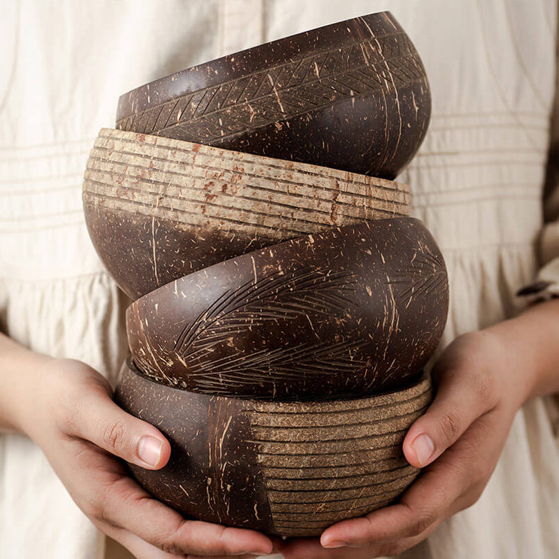 Bol en noix de coco fabriqué à la main tenu entre deux mains